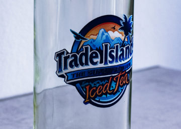 Eine Glasflasche, welche mit dem Logo von Trade Islands Iced Tea bedruckt ist